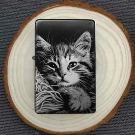Zeigt die Vorder- und Rückseite des personalisierbaren Feuerzeugs mit Katzenmotiv und einem Beispiel für eine Wunschgravur.