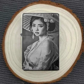 Personalisiertes Feuerzeug mit eleganter Geisha-Gravur unter einem traditionellen Hut, stimmungsvoll auf einer Baumscheibe arrangiert.