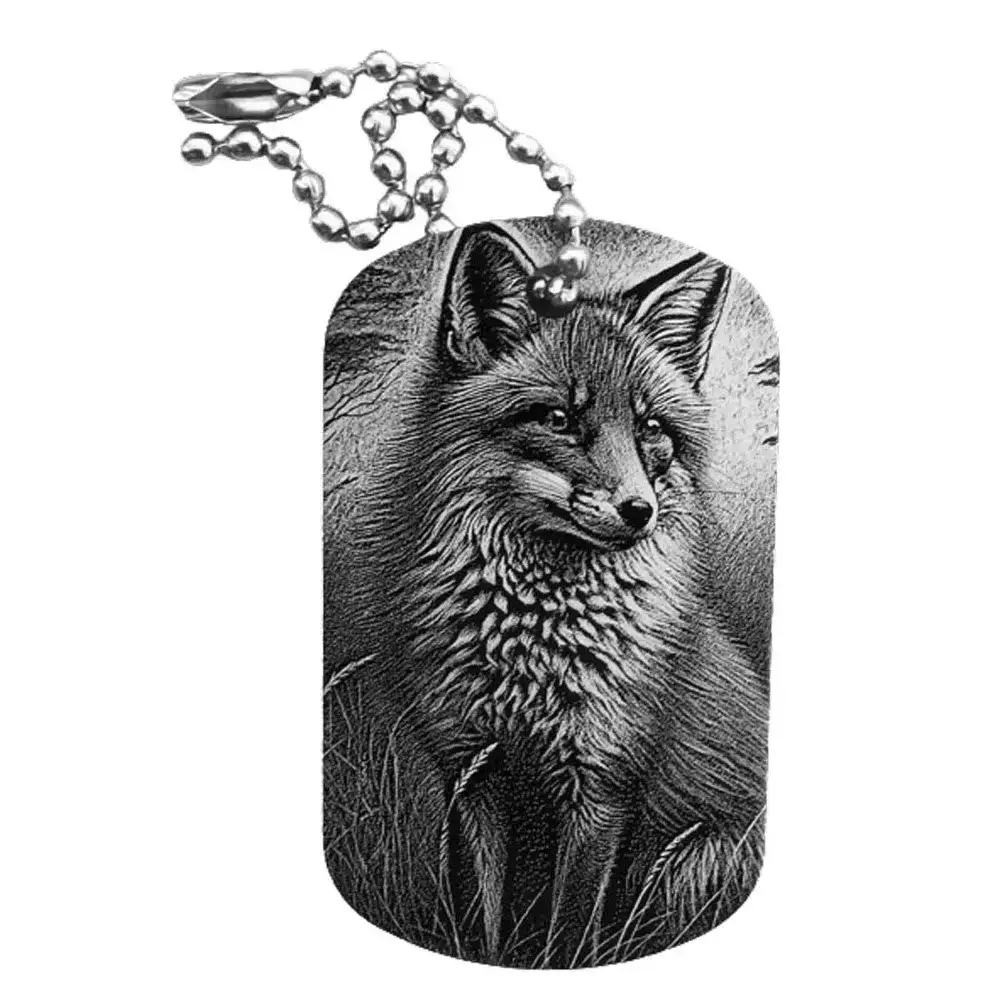 Schwarzer Dogtag Schlüsselanhänger mit detaillierter Lasergravur eines Fuchses in sitzender Position in der Natur.