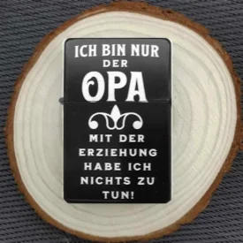 Personalisiertes Feuerzeug mit humorvollem Opa-Spruch, stimmungsvoll auf einer Holzscheibe arrangiert.