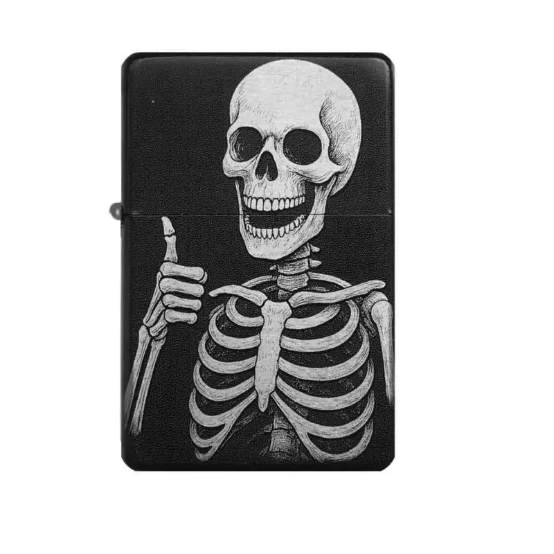 Frontansicht des mattschwarzen Benzinfeuerzeugs mit einer detailreichen Gravur eines Skeletts, das mit grinsendem Gesicht den Daumen nach oben streckt.