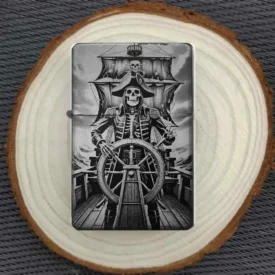 Personalisiertes Feuerzeug mit Piratenskelett am Steuerrad-Motiv, stimmungsvoll auf einer Holzscheibe arrangiert.