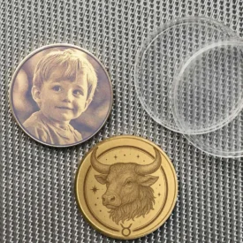 Beispiel einer personalisierten Sternzeichen Stier Münze mit Fotogravur eines Kindes auf der Rückseite.