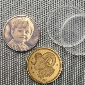 Beispiel einer personalisierten Sternzeichen Widder Münze mit Fotogravur eines Kindes auf der Rückseite.