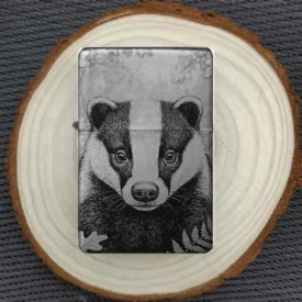 Dachskopf Feuerzeug Porträt Gravur, Schwarz mattes Metallfeuerzeug mit detailliertem Tiergesicht und Farn-Elementen auf einer Holzscheibe.