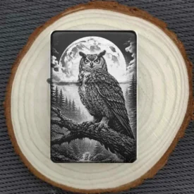 Personalisiertes Benzinfeuerzeug mit Uhu vor Mond, schwarze Matt-Optik mit feiner Metallgravur.